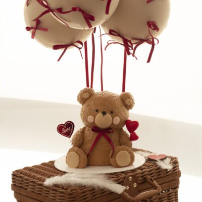 a bear made of cake sitting on a basket